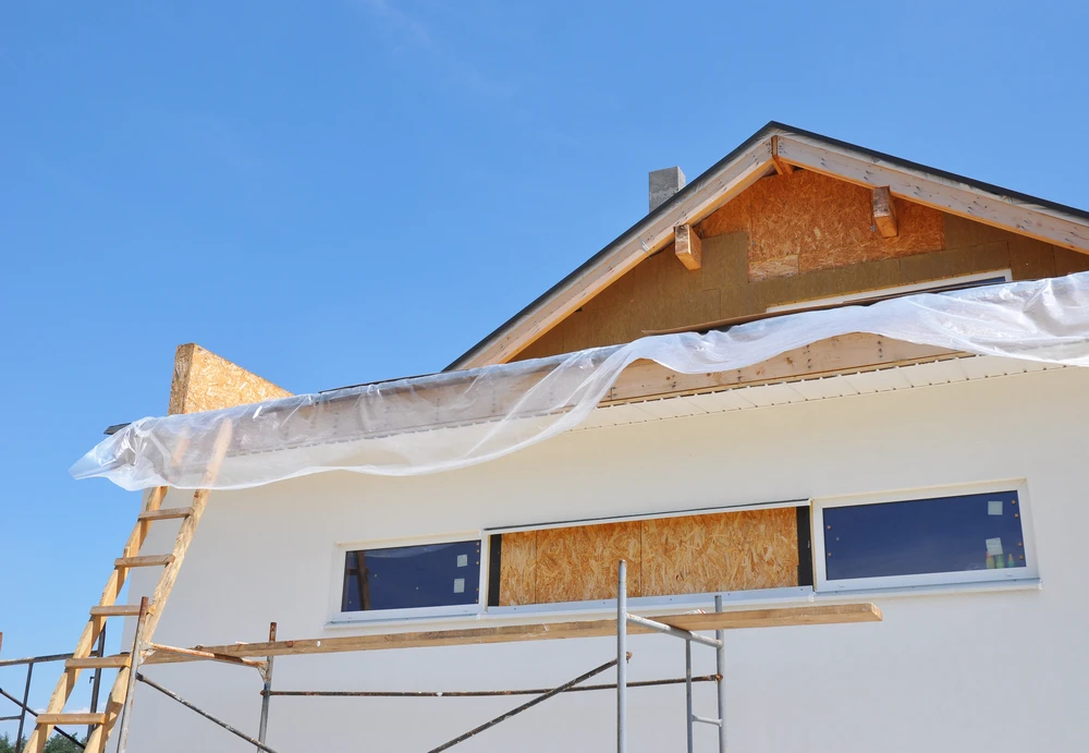 Maison contemporaine à deux niveaux avec architecture moderne mixant crépi beige, parement brique et bardage métallique anthracite