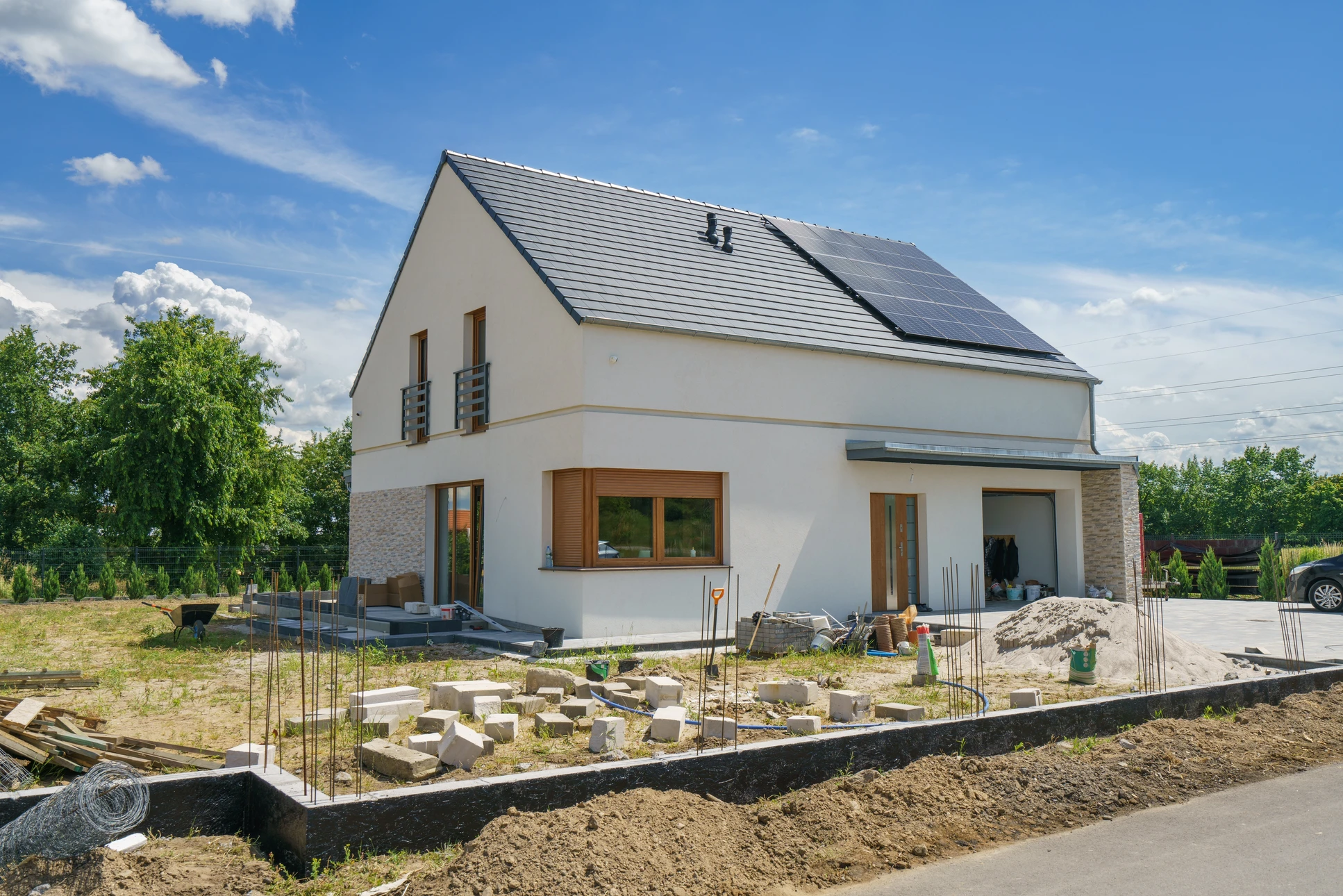 Un maçon qualifié vérifie le niveau de briques fraîchement posées sur un chantier de construction à la lumière du soleil de l'après-midi