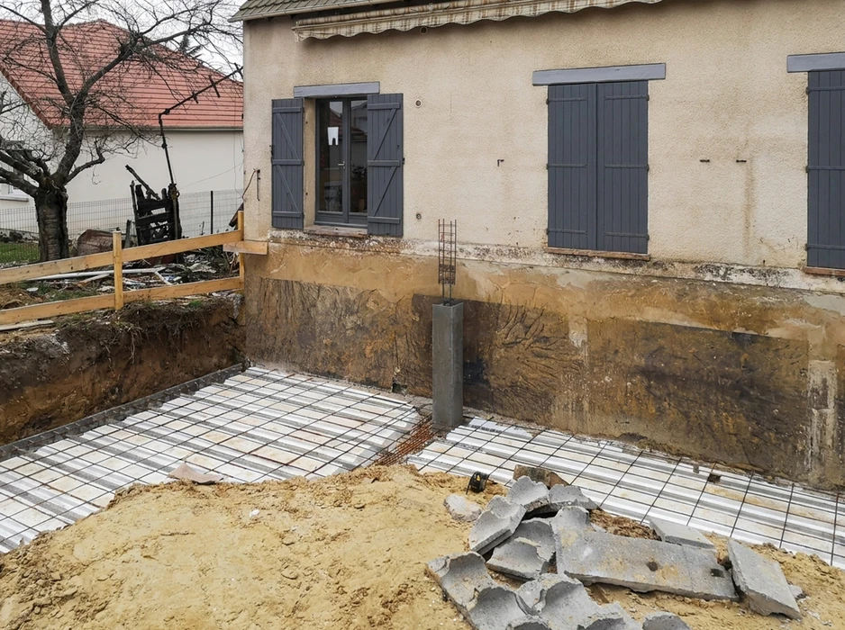 Chantier d'extension en cours, façade maison ancienne exposée après terrassement