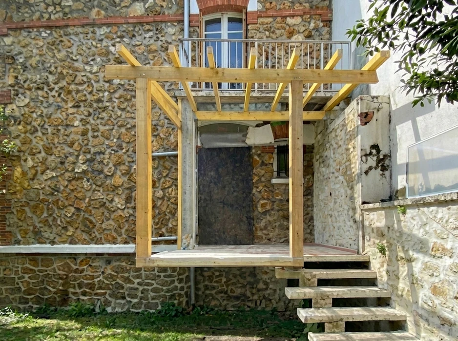 Structure de pergola en bois neuf (épicéa ou pin traité) montée sur terrasse en maçonnerie pierre calcaire, en cours de rénovation