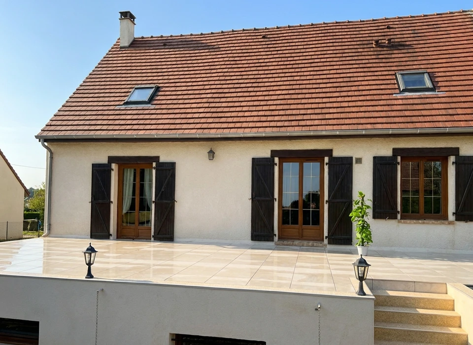 Maison pavillonnaire française avec terrasse extérieure en carrelage grès cérame poli grand format, pose en joint droit