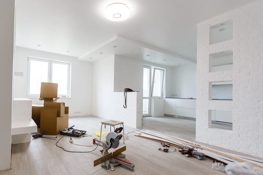 Ouvrier professionnel appliquant un enduit de lissage sur mur intérieur dans cuisine en rénovation