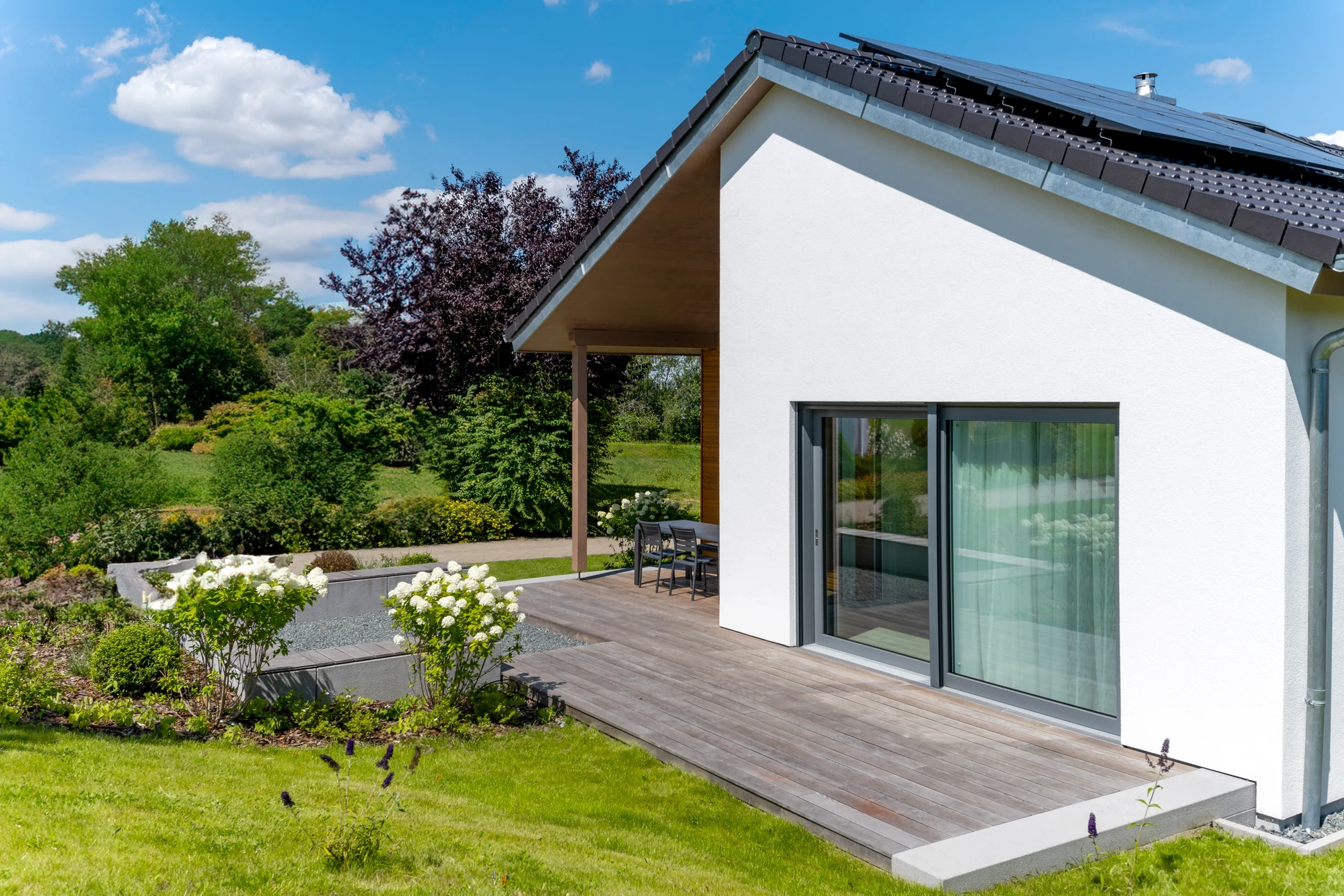 Extension de maison en construction avec murs en blocs de béton, toiture neuve en tuiles grises, échafaudage temporaire